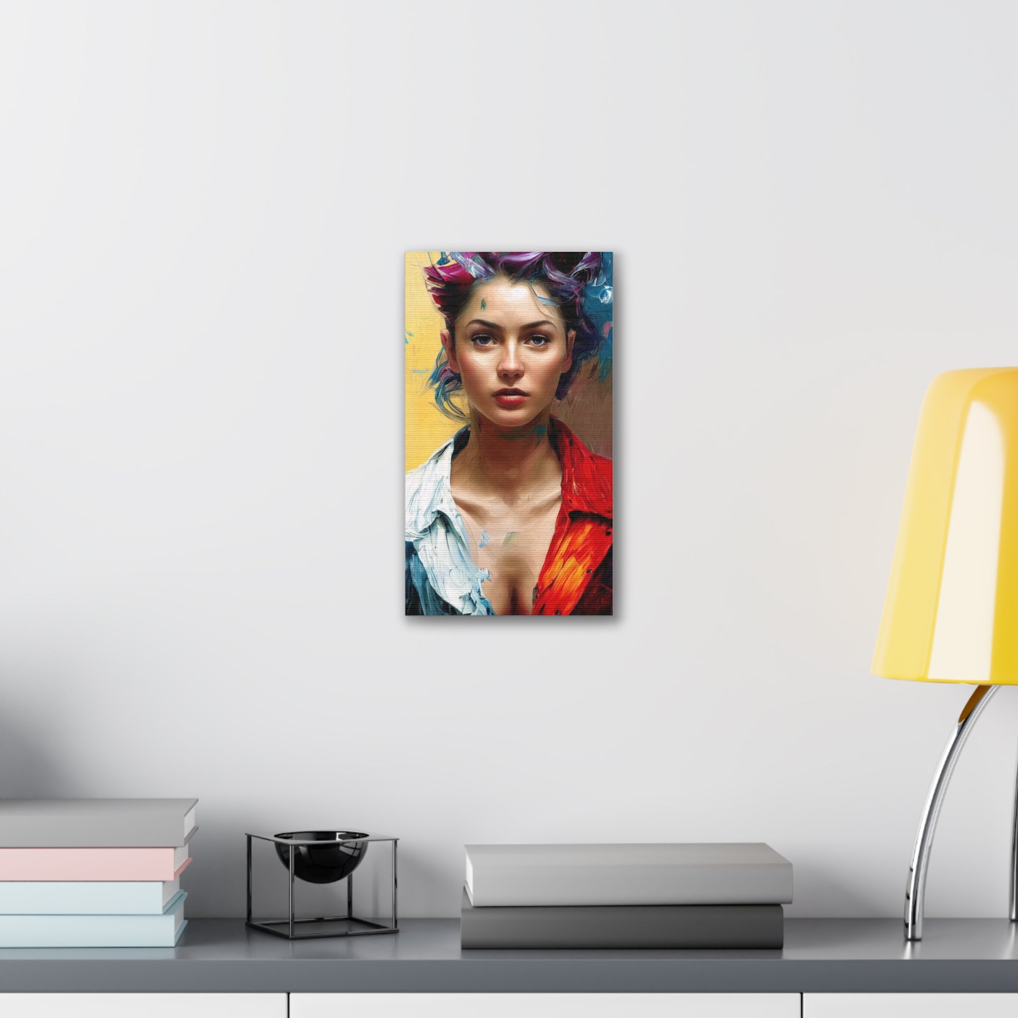 Canvas print of a stylized portrait on a wall above a desk with books and a lamp.