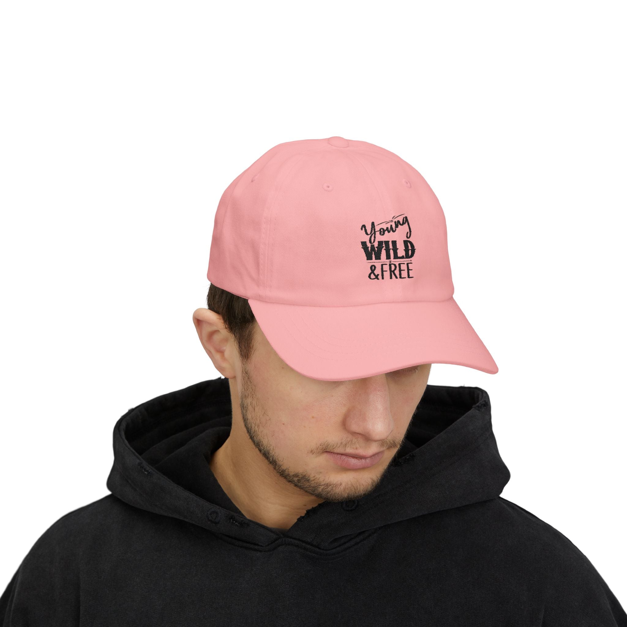 Person wearing a pink cap with 'Young Wild Free' text on a white background