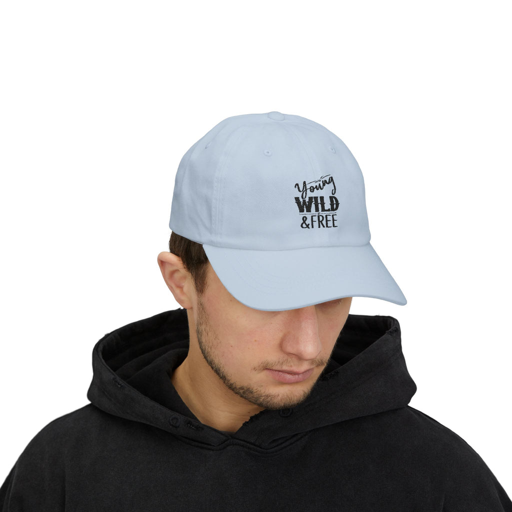 Light blue cap with 'Young Wild Free' text worn by a person in a black hoodie on a white background