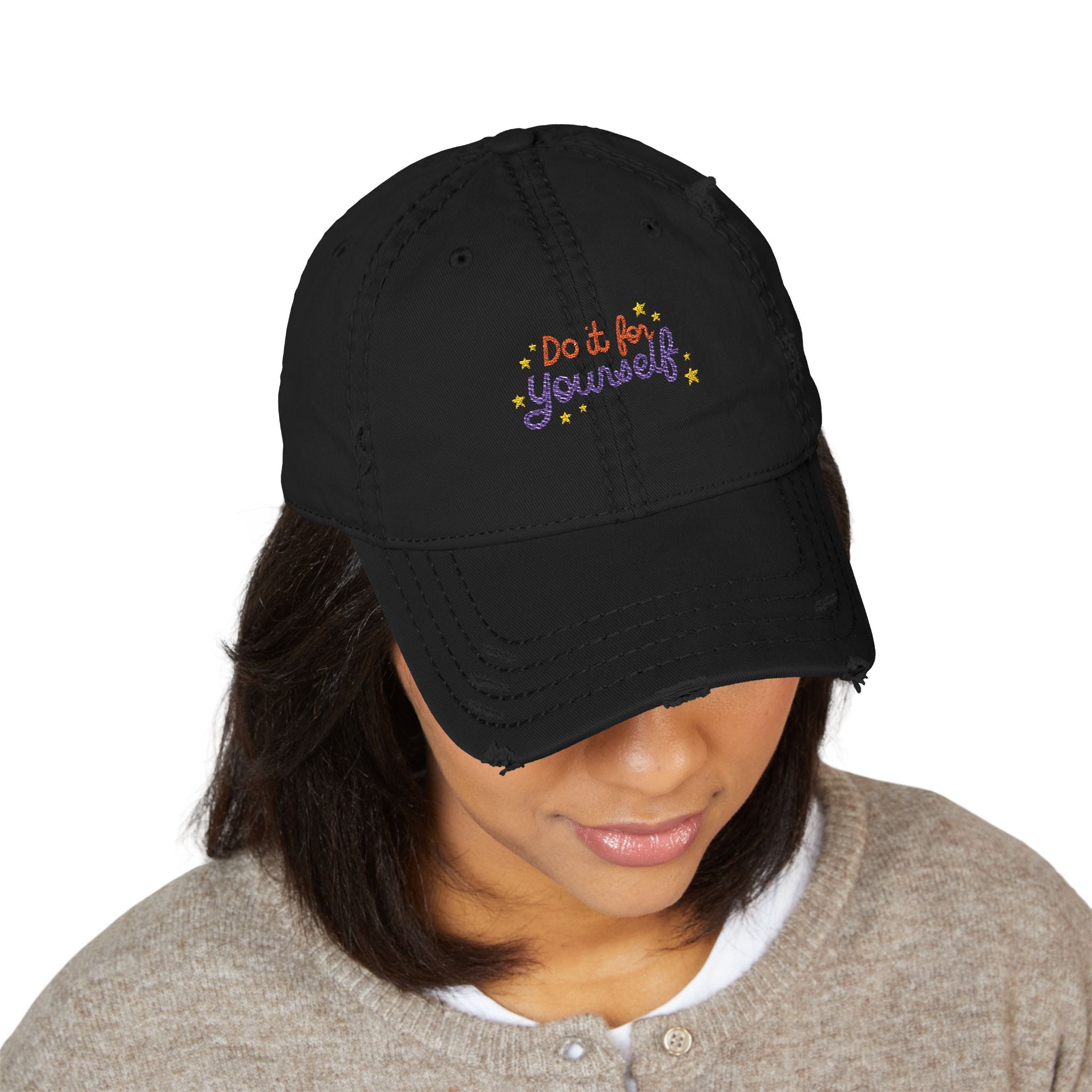 Black cap with 'Do it for yourself' text worn by a person on a white background