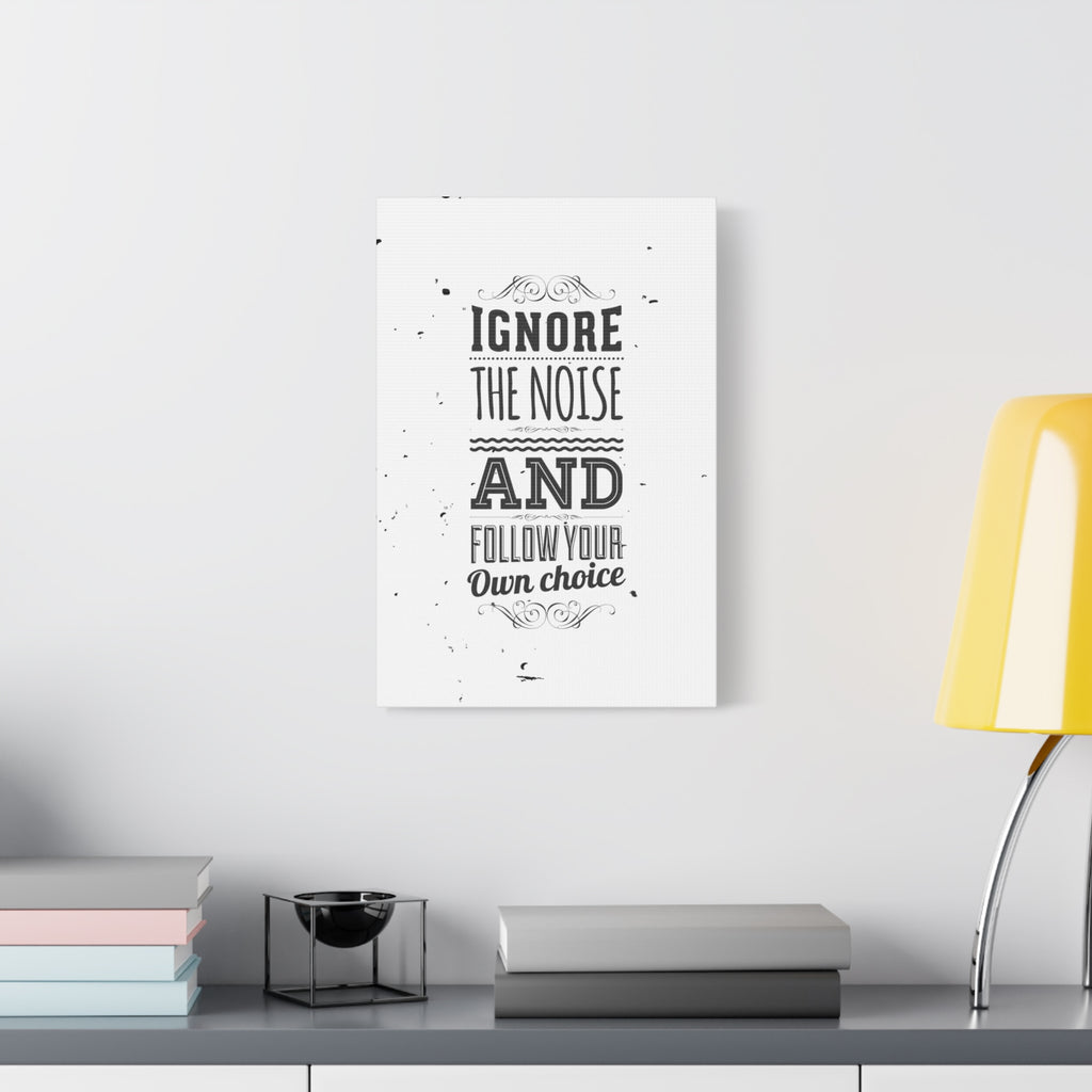 Motivational poster with text on a wall above a desk with books and a lamp.
