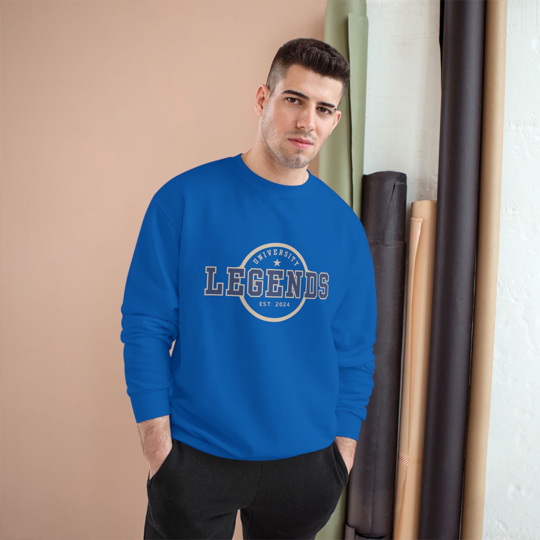 Man wearing a blue sweatshirt with 'Legends' text, standing indoors against a neutral wall.