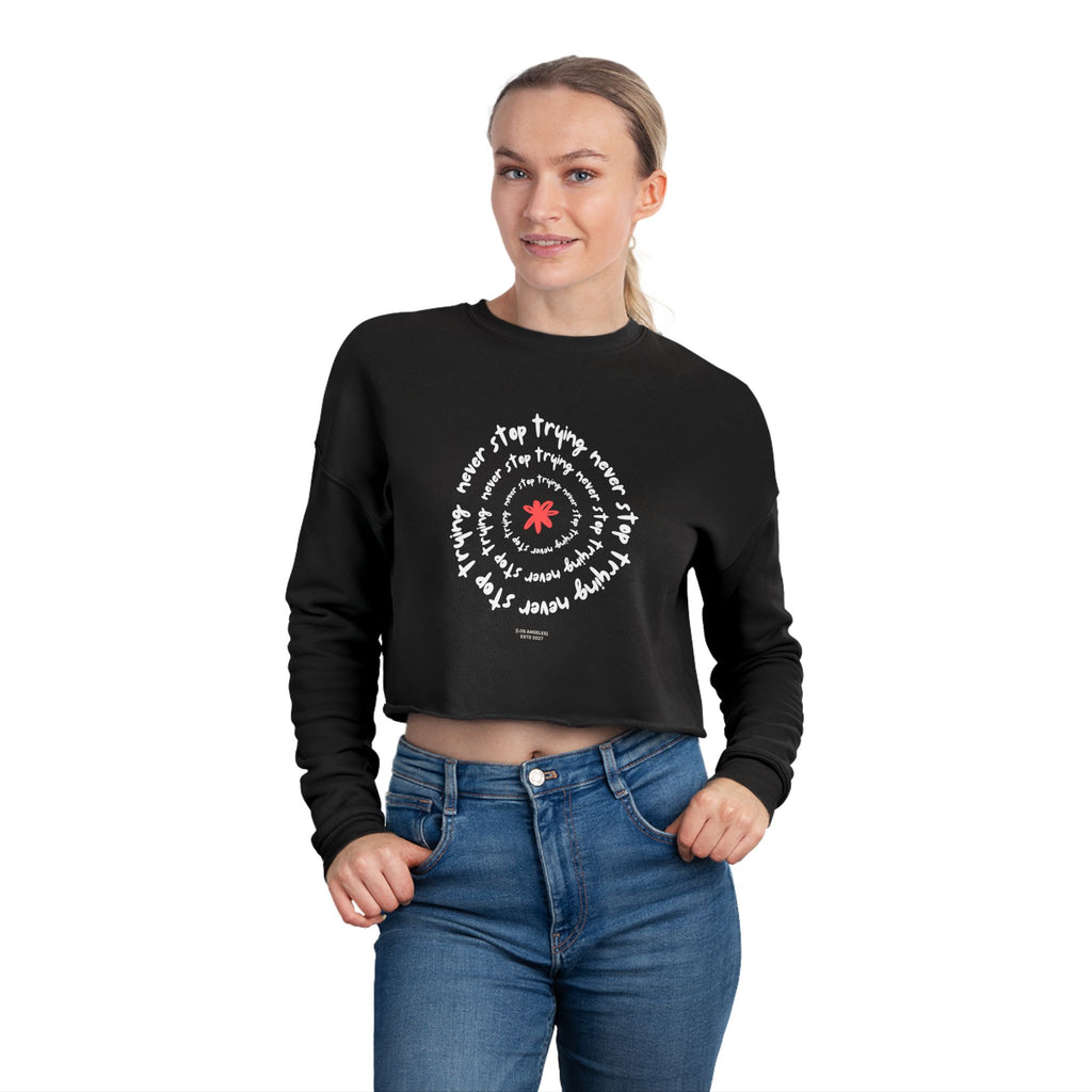 Person wearing a black cropped sweatshirt with white text design on a white background