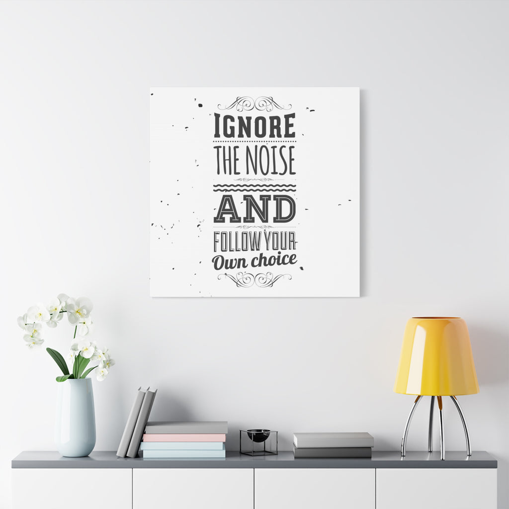Wall art with motivational quote on a white wall above a shelf with decor items.