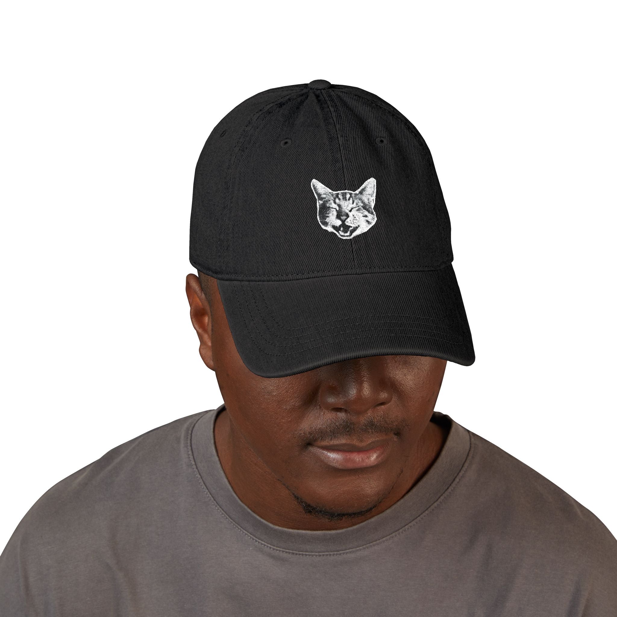 Man wearing a black cap with a cat face design on a white background