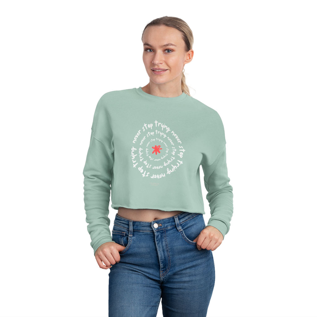 Woman wearing a light green sweatshirt with a graphic design on a white background