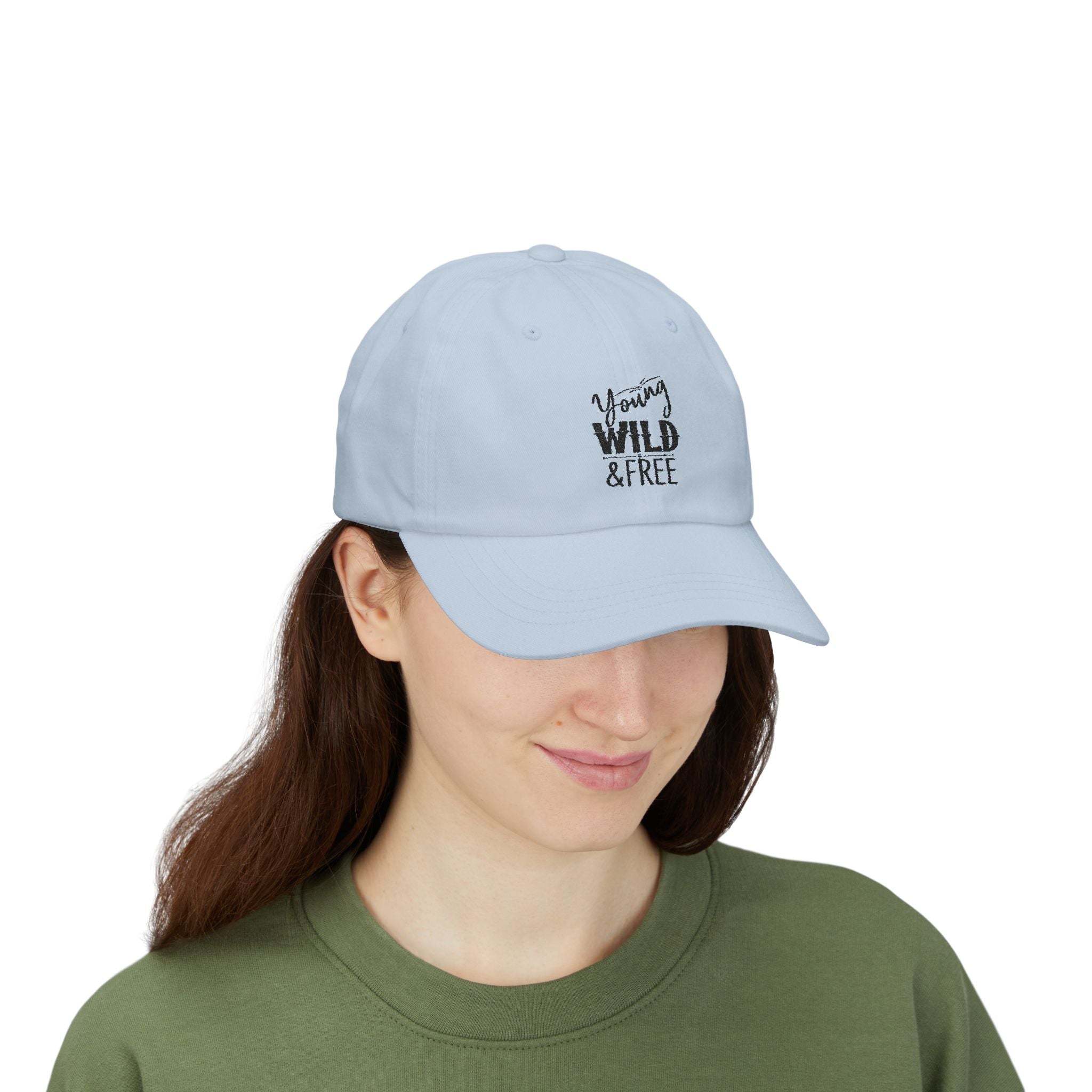 Light blue cap with 'Young Wild & Free' text worn by a person on a white background