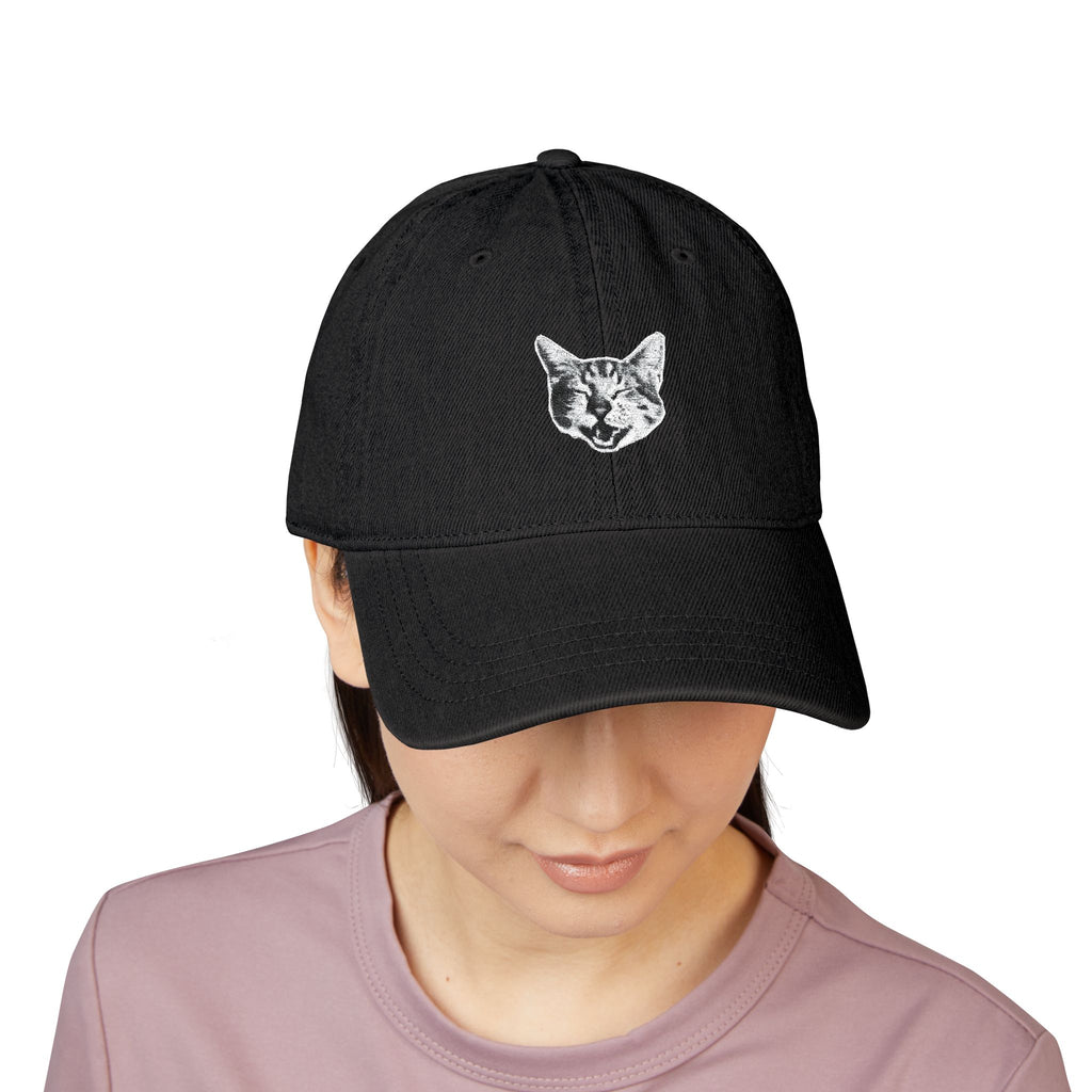 Black cap with a cat design worn by a person on a white background