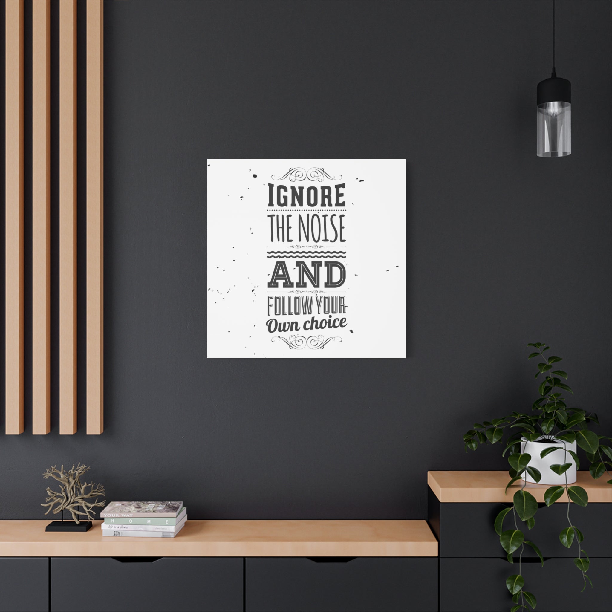 Framed poster with motivational quote on a dark wall above a wooden shelf.