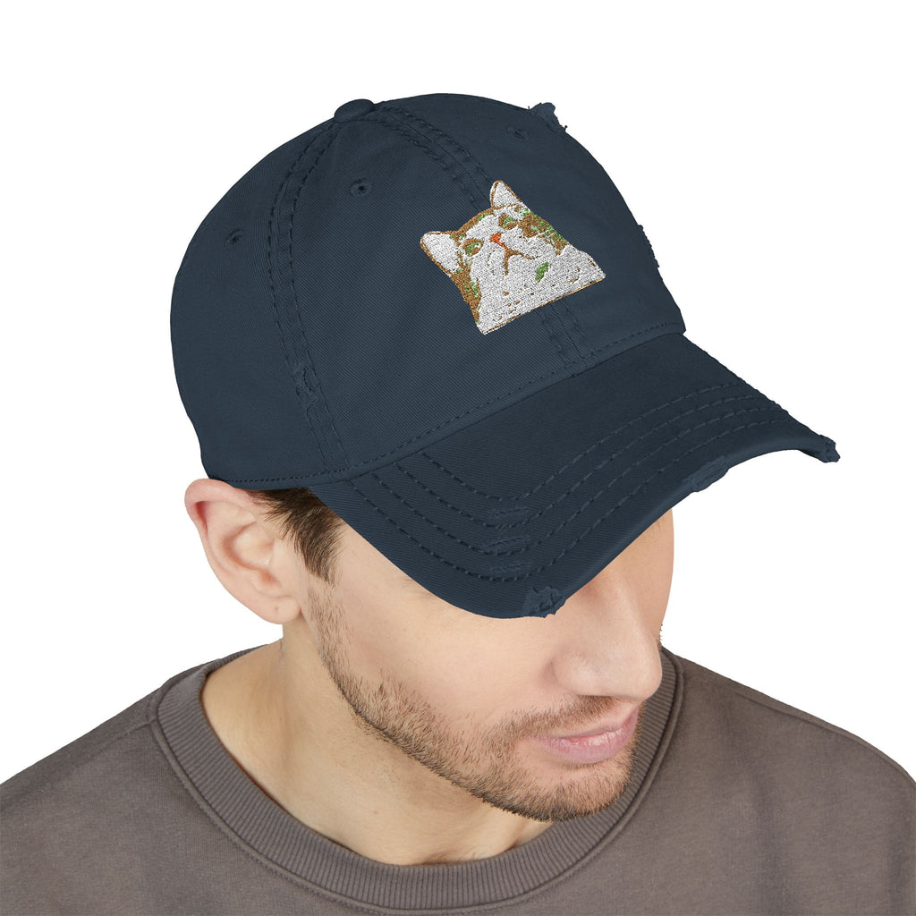 Navy blue cap with a small embroidered design worn by a person on a white background