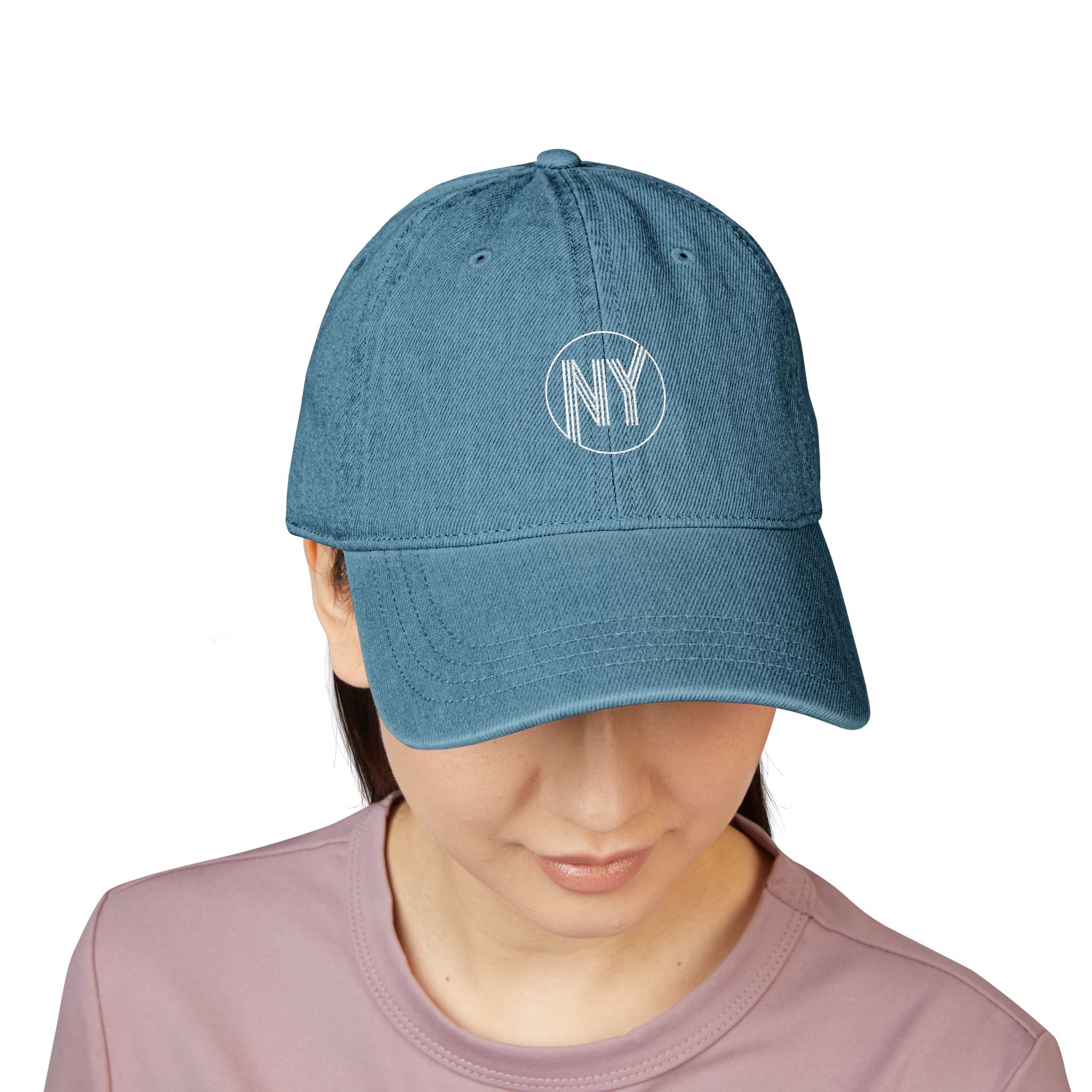 Blue cap with 'NY' logo worn by a person on a white background