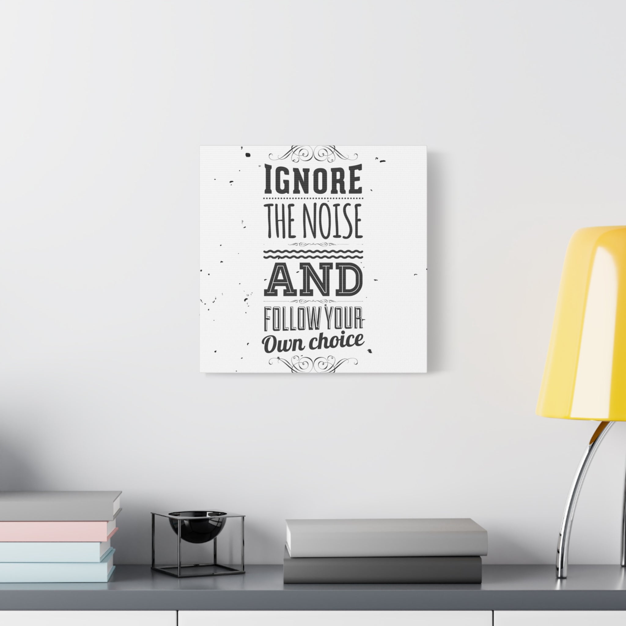 Decorative wall art with motivational quote on a white wall above a desk.