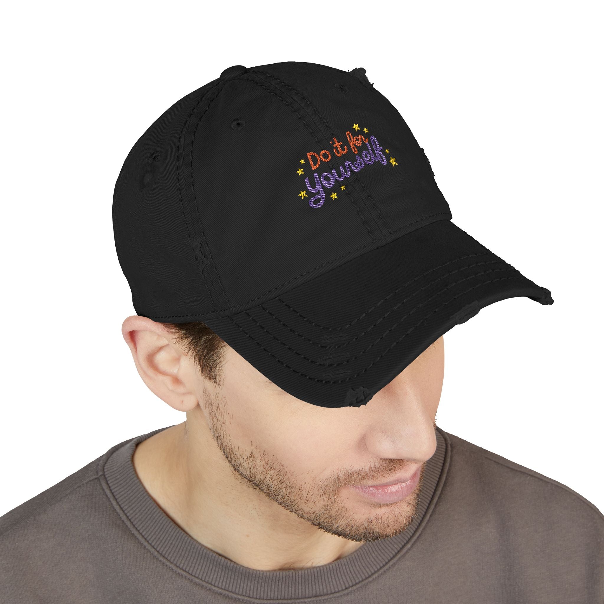 Black cap with 'Do it for yourself' embroidery worn by a person on a white background