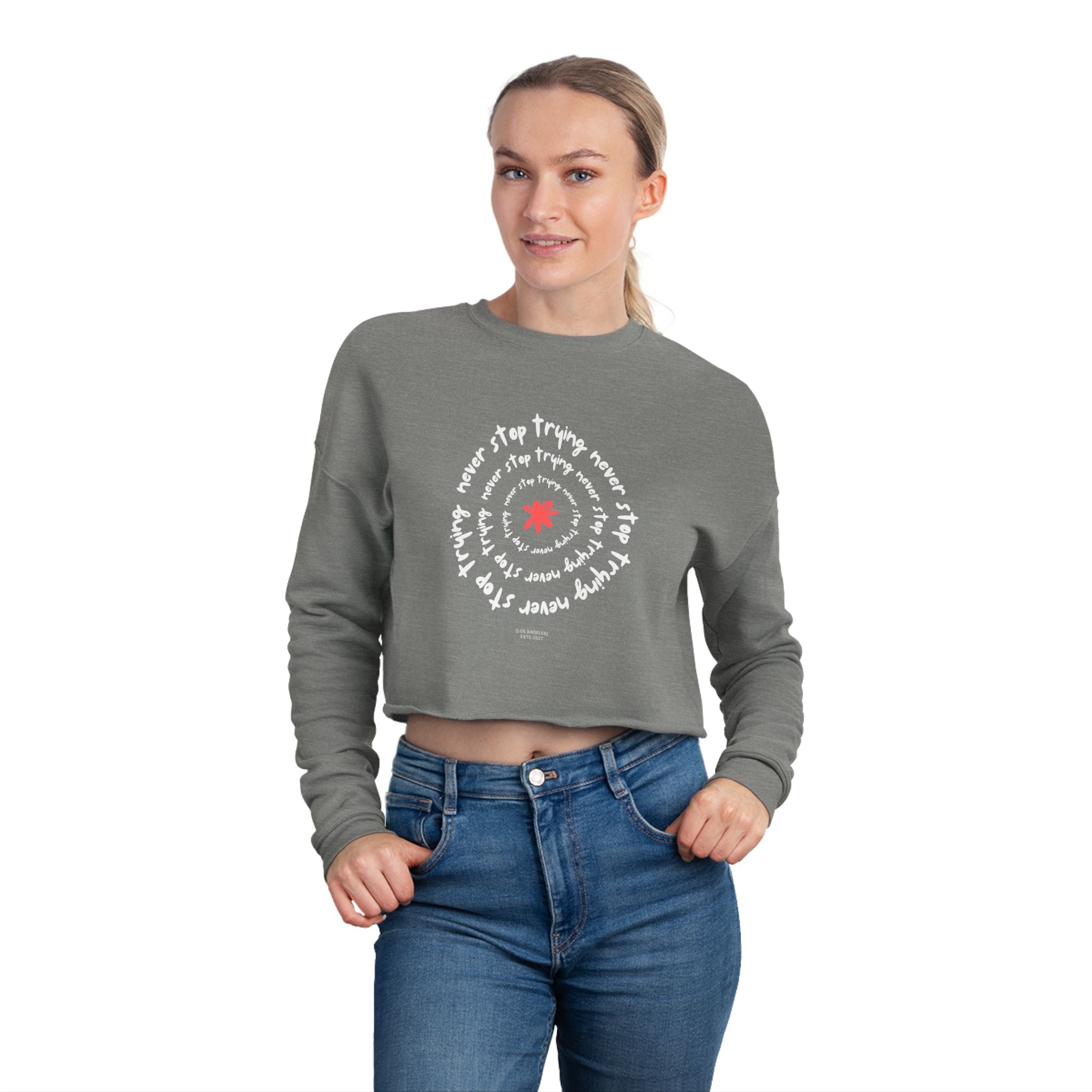 Woman wearing a gray cropped sweatshirt with text and a red circle design on a white background