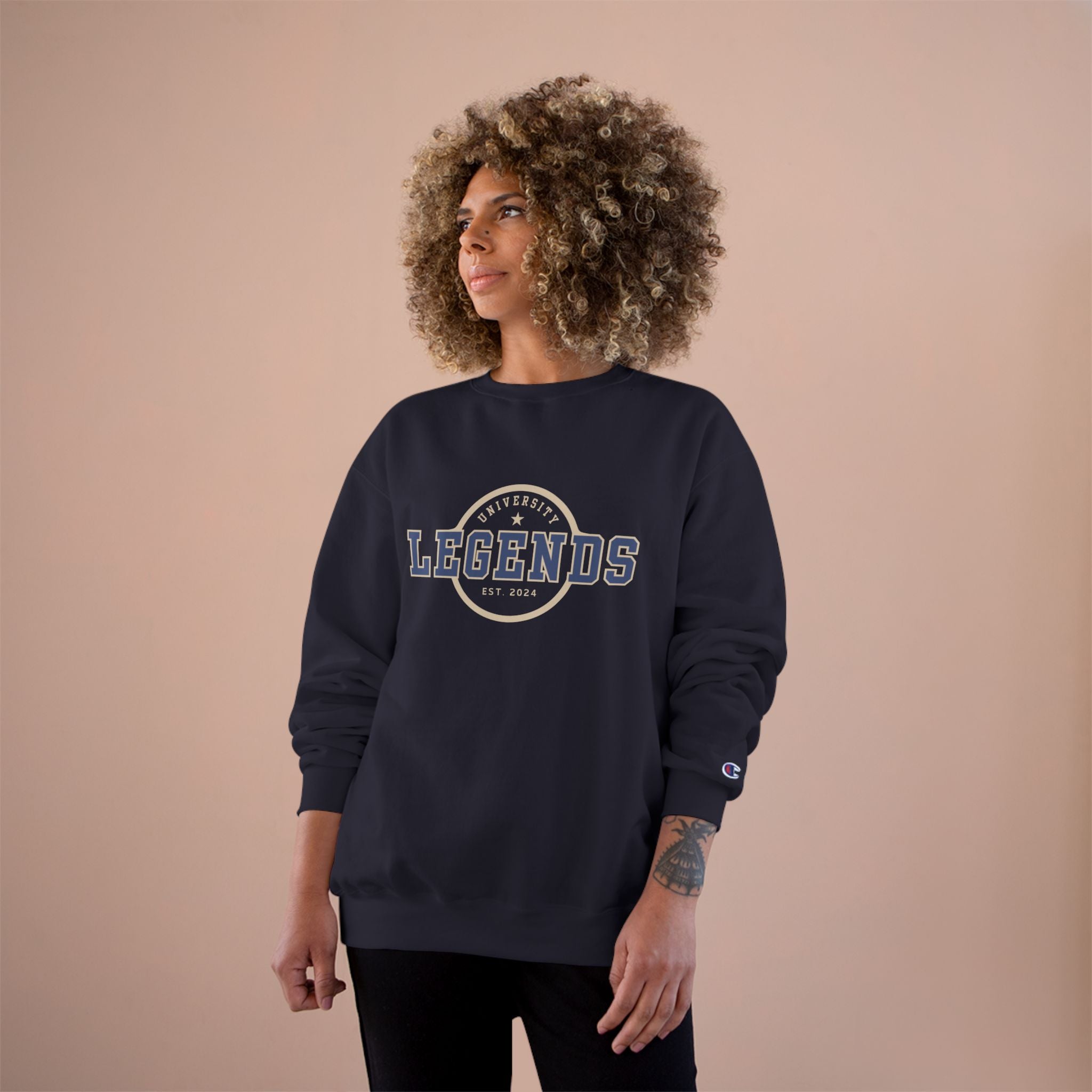 Person wearing a navy sweatshirt with 'Legends' text on a beige background